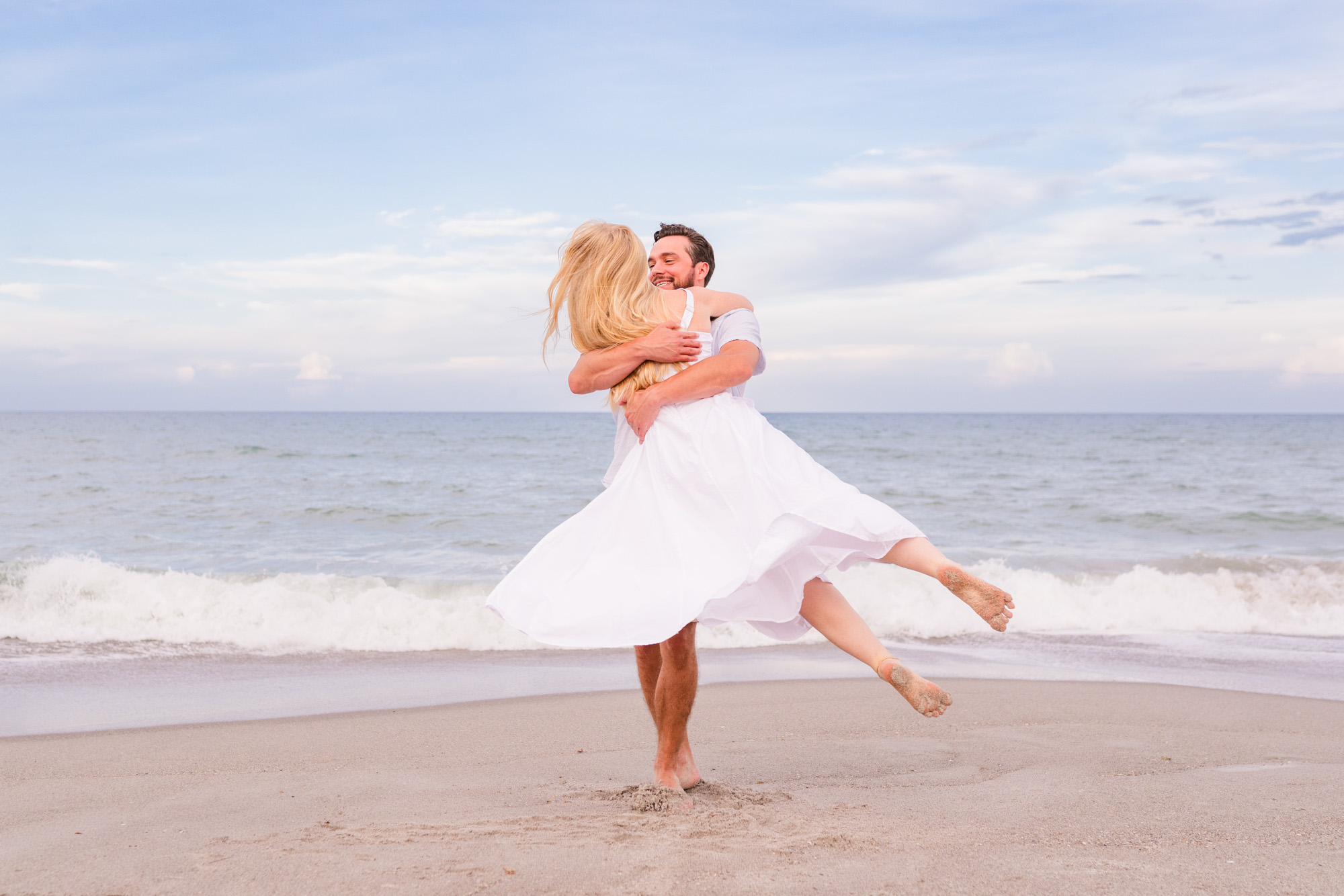Man spinning woman whose dress is flaring out on Melbourne Beach