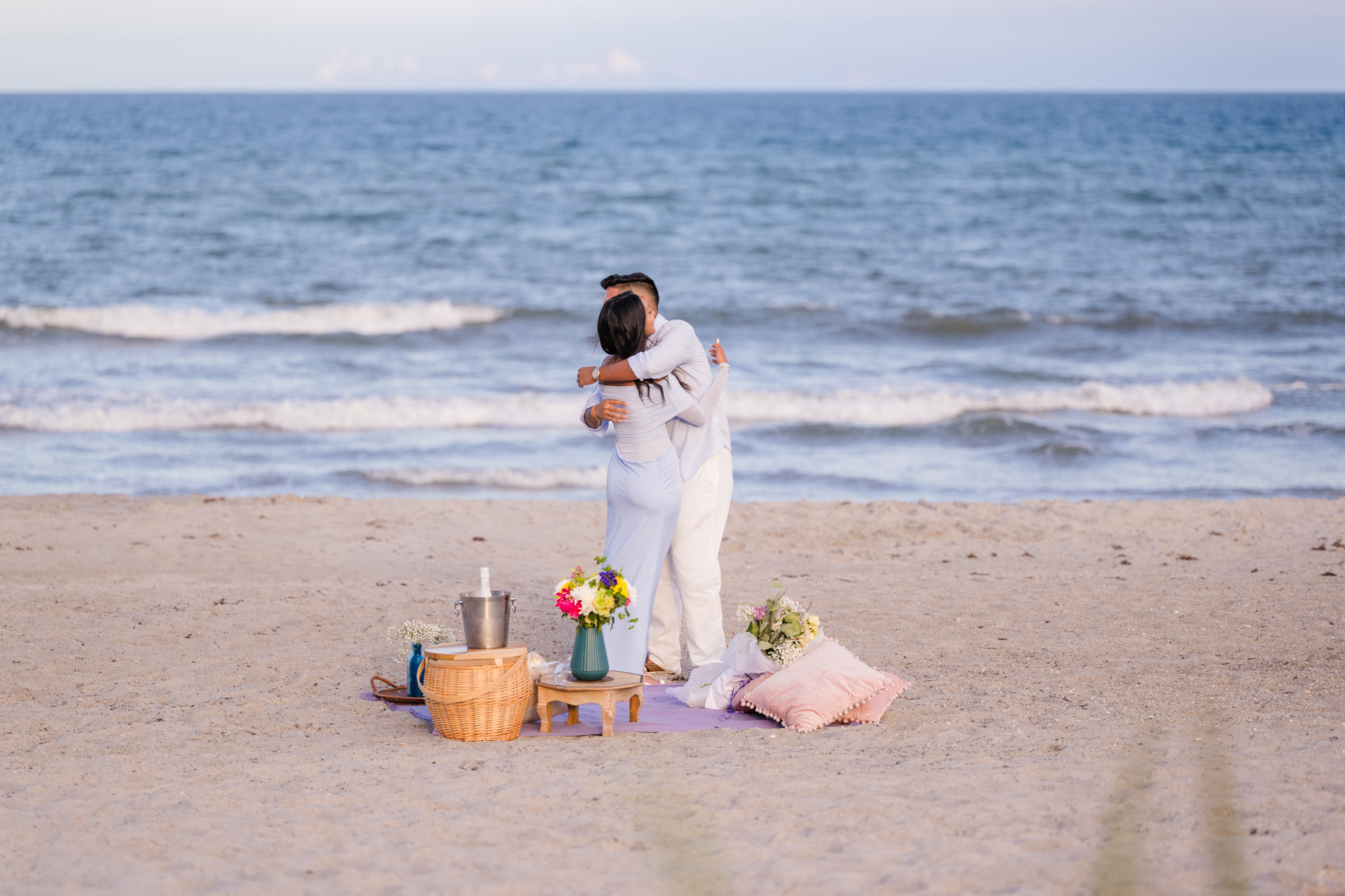 Man and woman hugging right after he proposed to her on Cocoa Beach, Florida