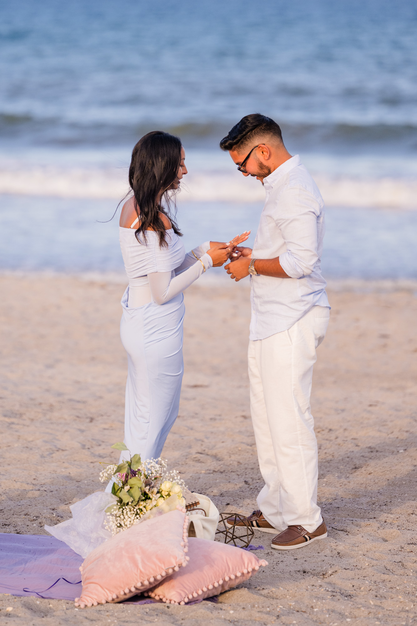 couple looking at the ring after beach proposal