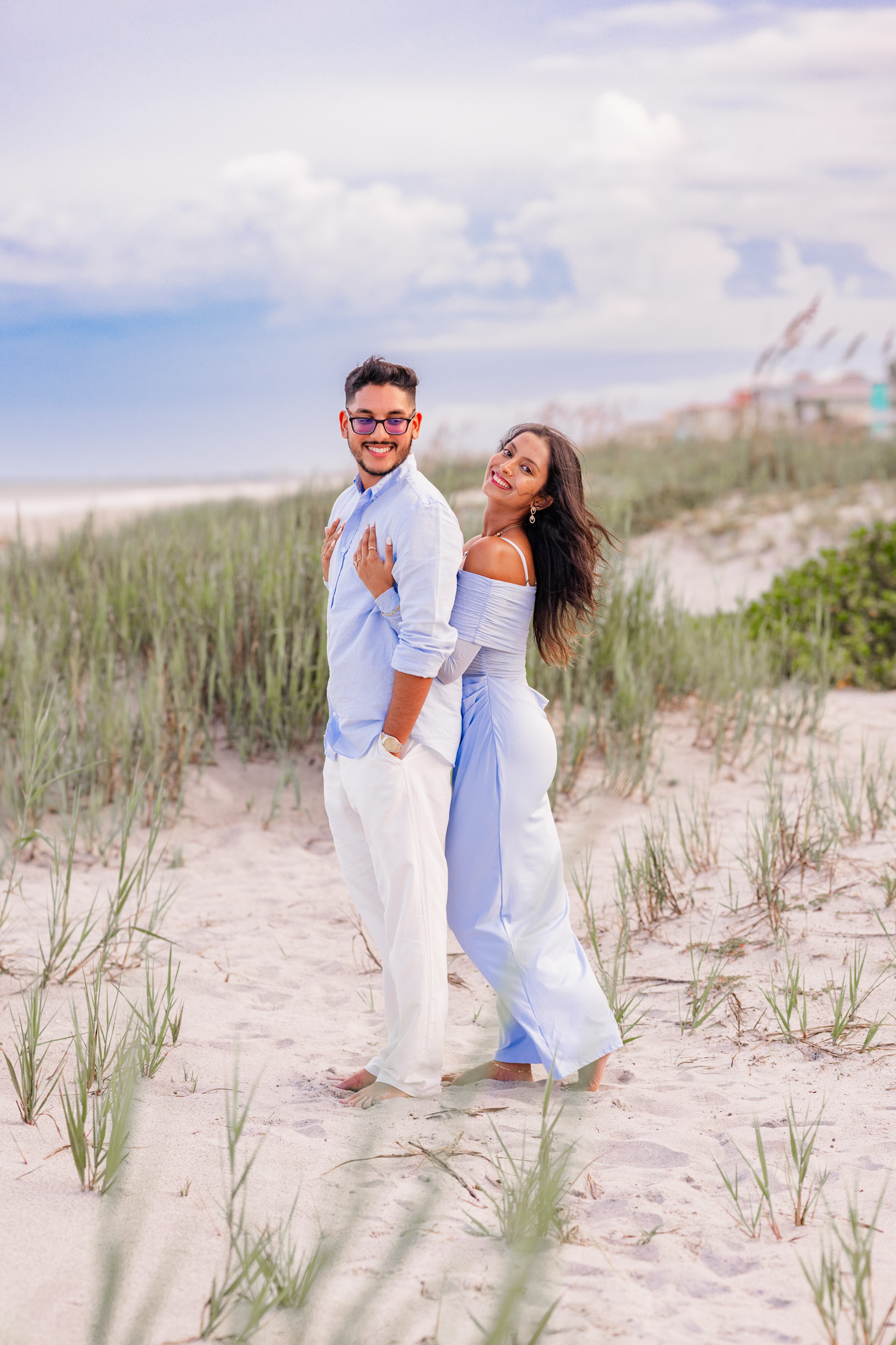 woman hugging on man in the dunes on Cocoa Beach, Florida