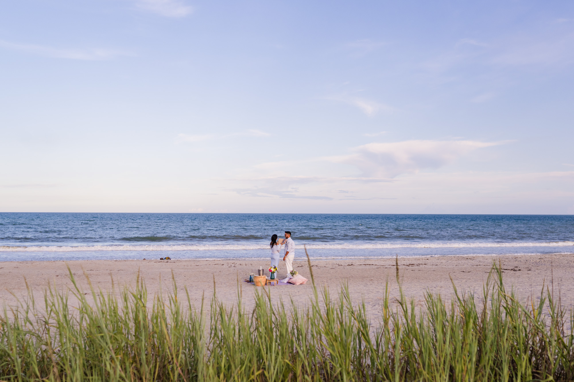 view of couple from behind the dunes