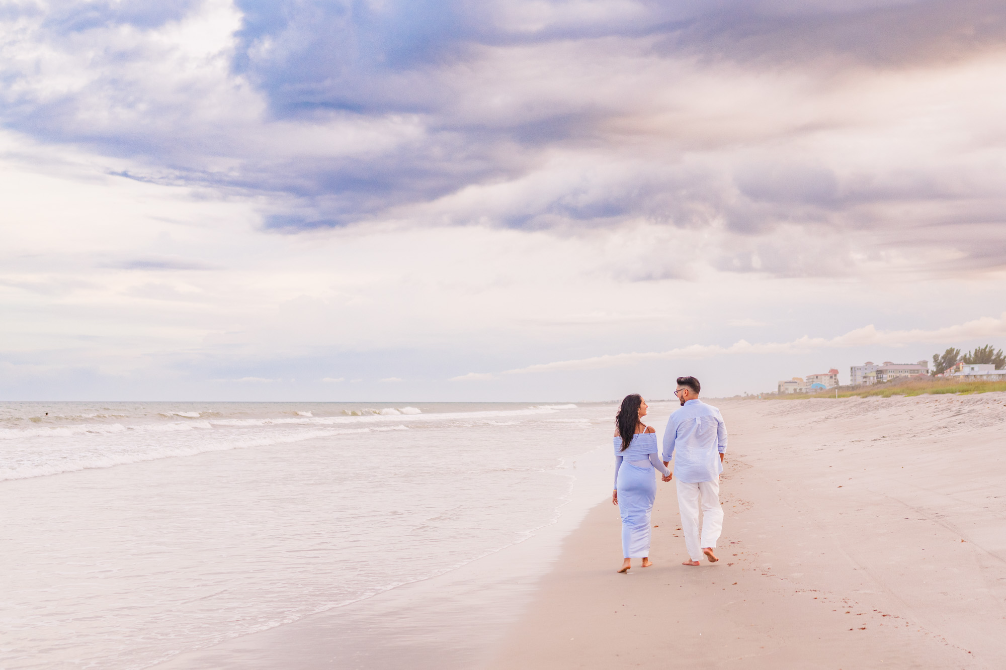 Couple walking down the beach during a beautiful sunset
