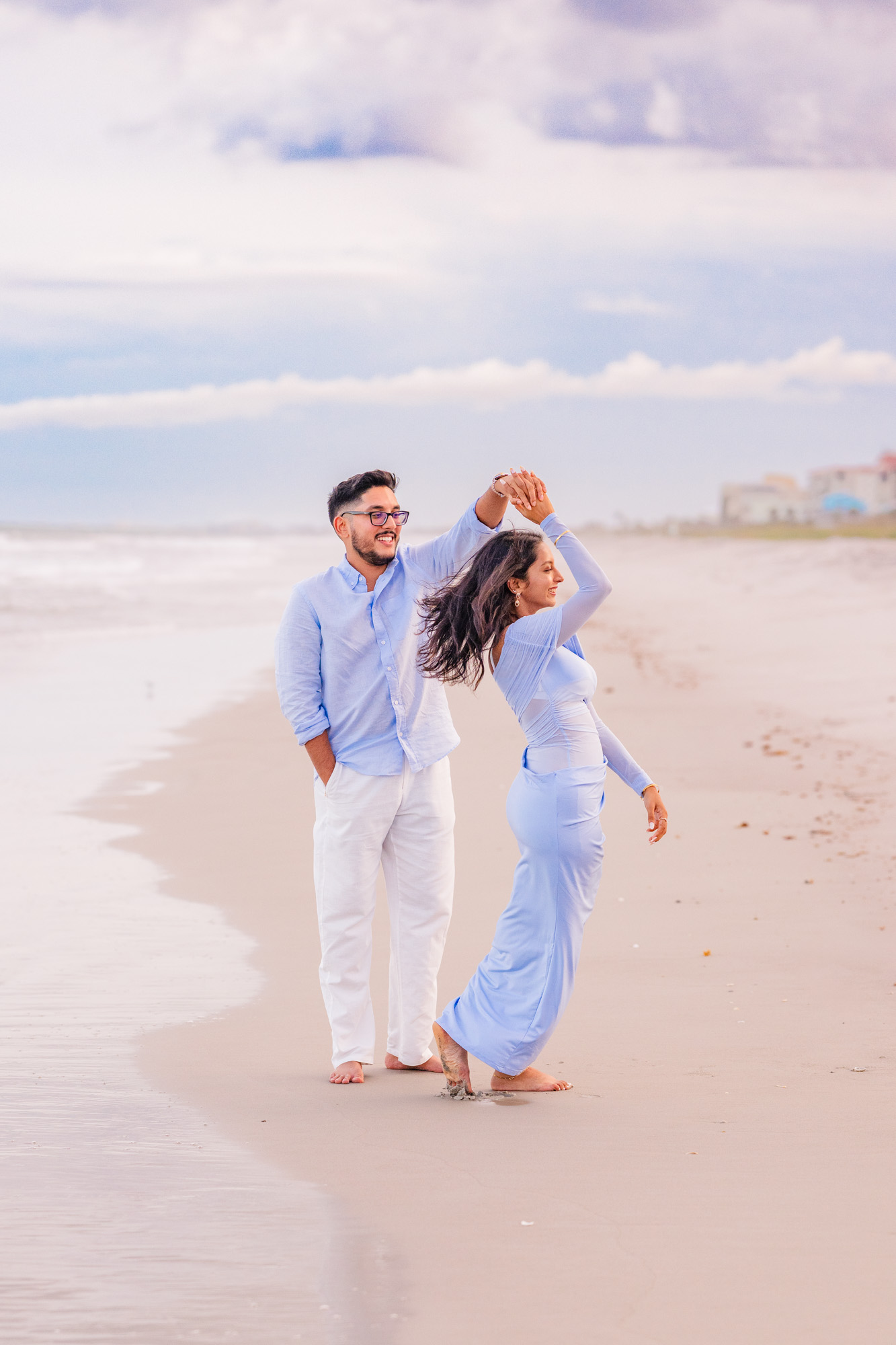 Man twirling woman in blue dress on Cocoa Beach