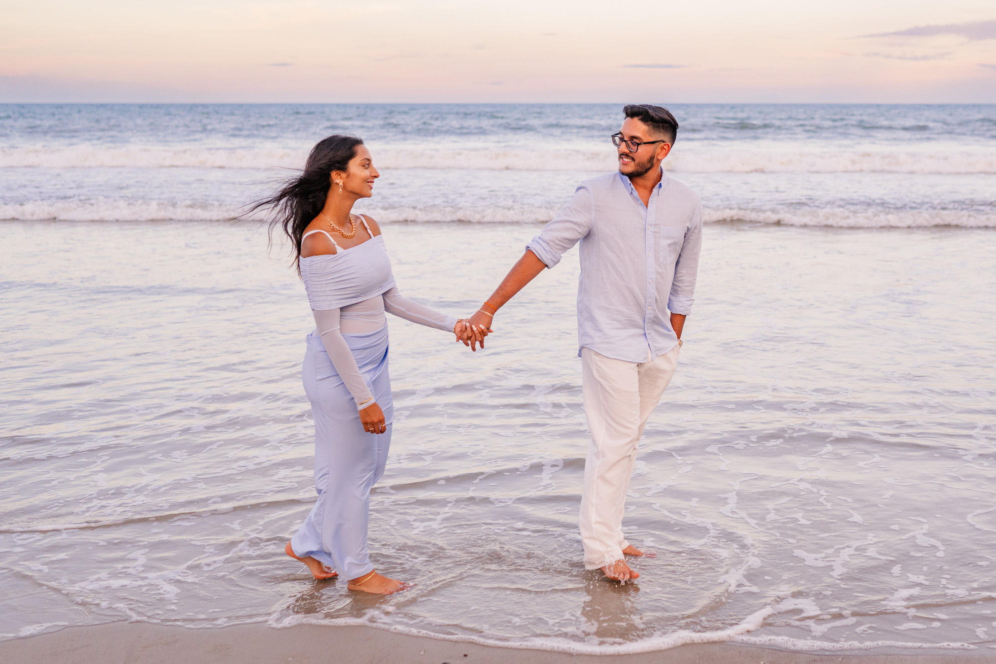 Couple walking holding hands both wearing blue