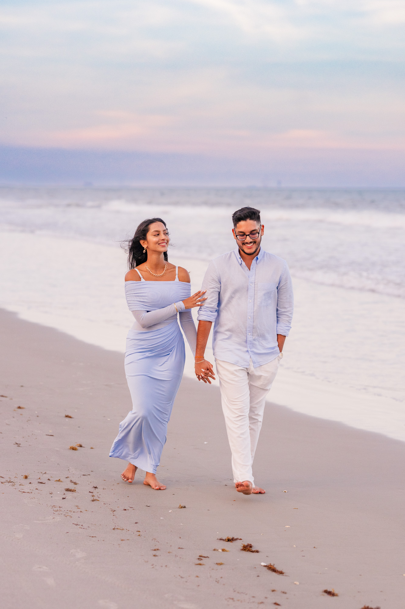 Man and woman walking arm in arm down Cocoa Beach