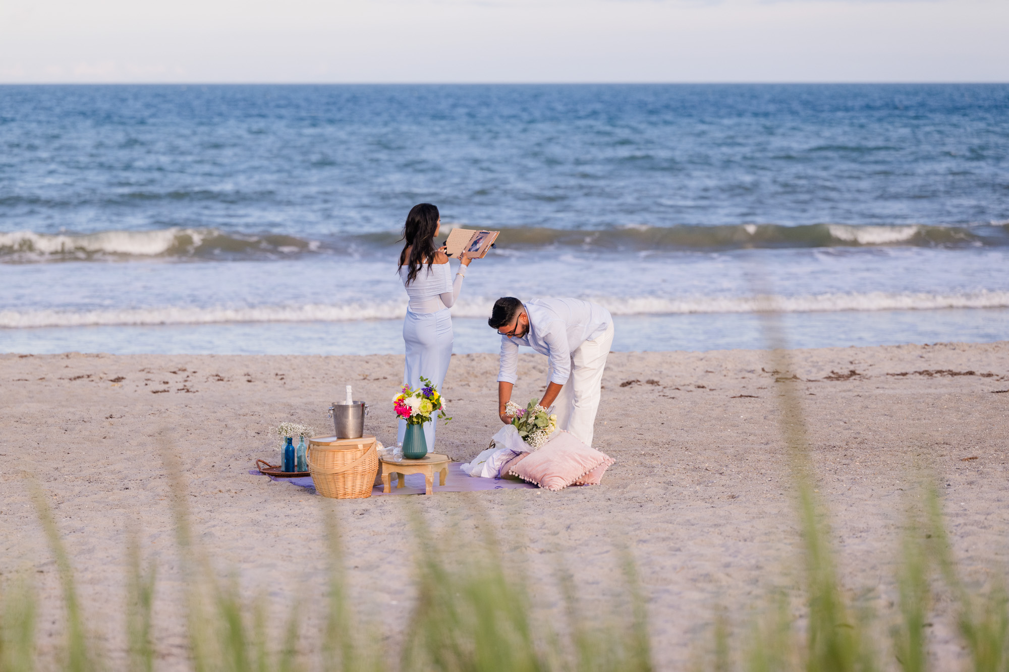 Man getting ready to go down on one knee to propose to his girlfriend on the beach in Cocoa Beach