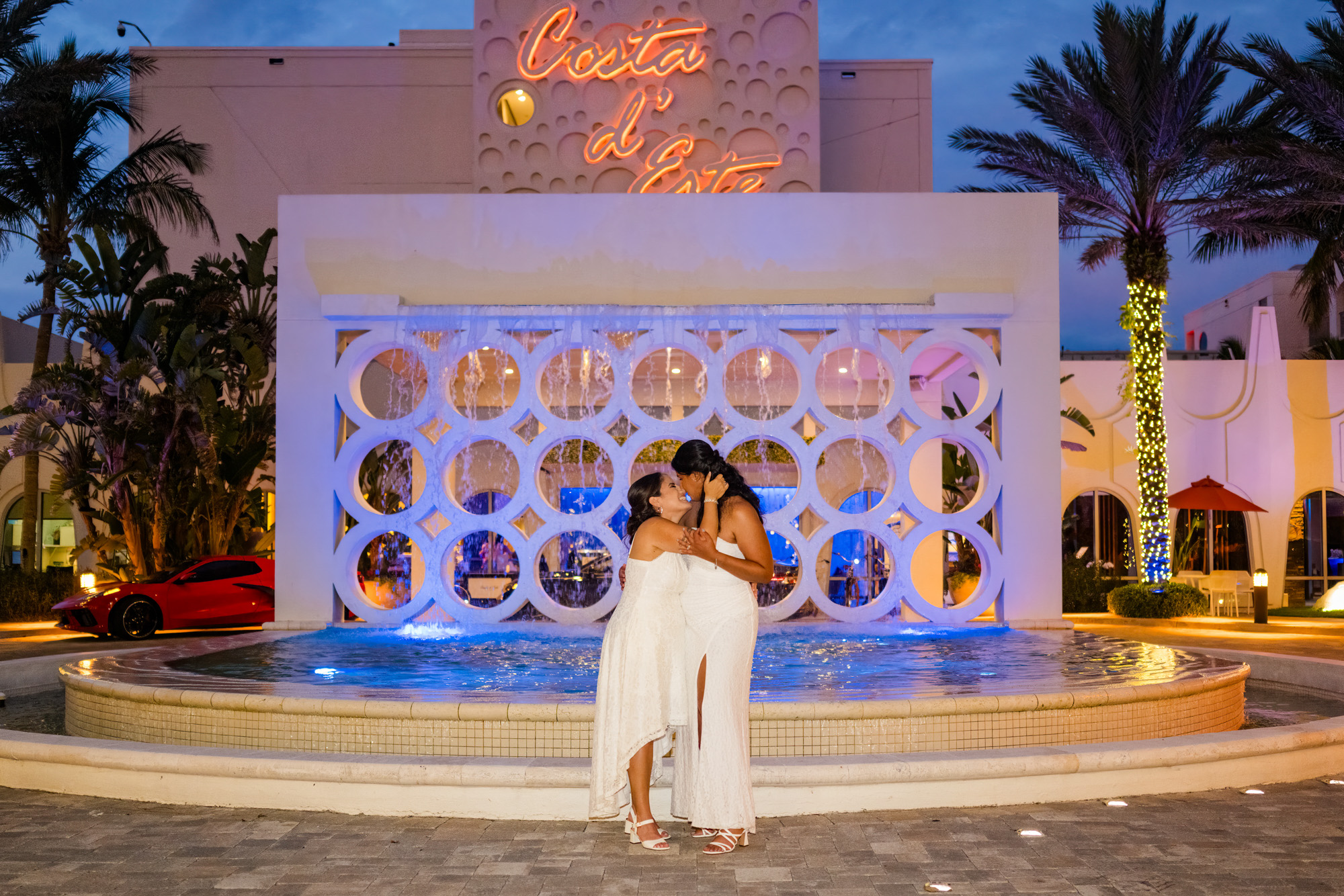 Exterior of Costa d’Este Beach Resort in Vero Beach with its fountain, palm trees, and illuminated sign.