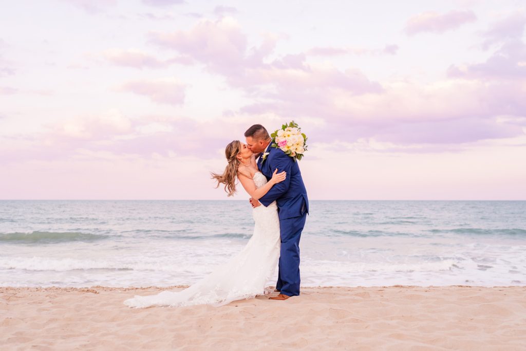 Couple hugging on the beach with a beautiful sunset after their elopement at Harbour House Oceanfront Venue