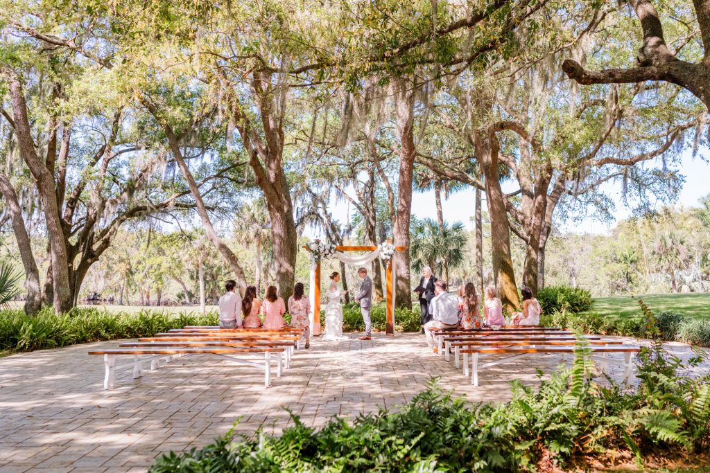 wide picture of couple during elopement at up the creek farms under the oak trees