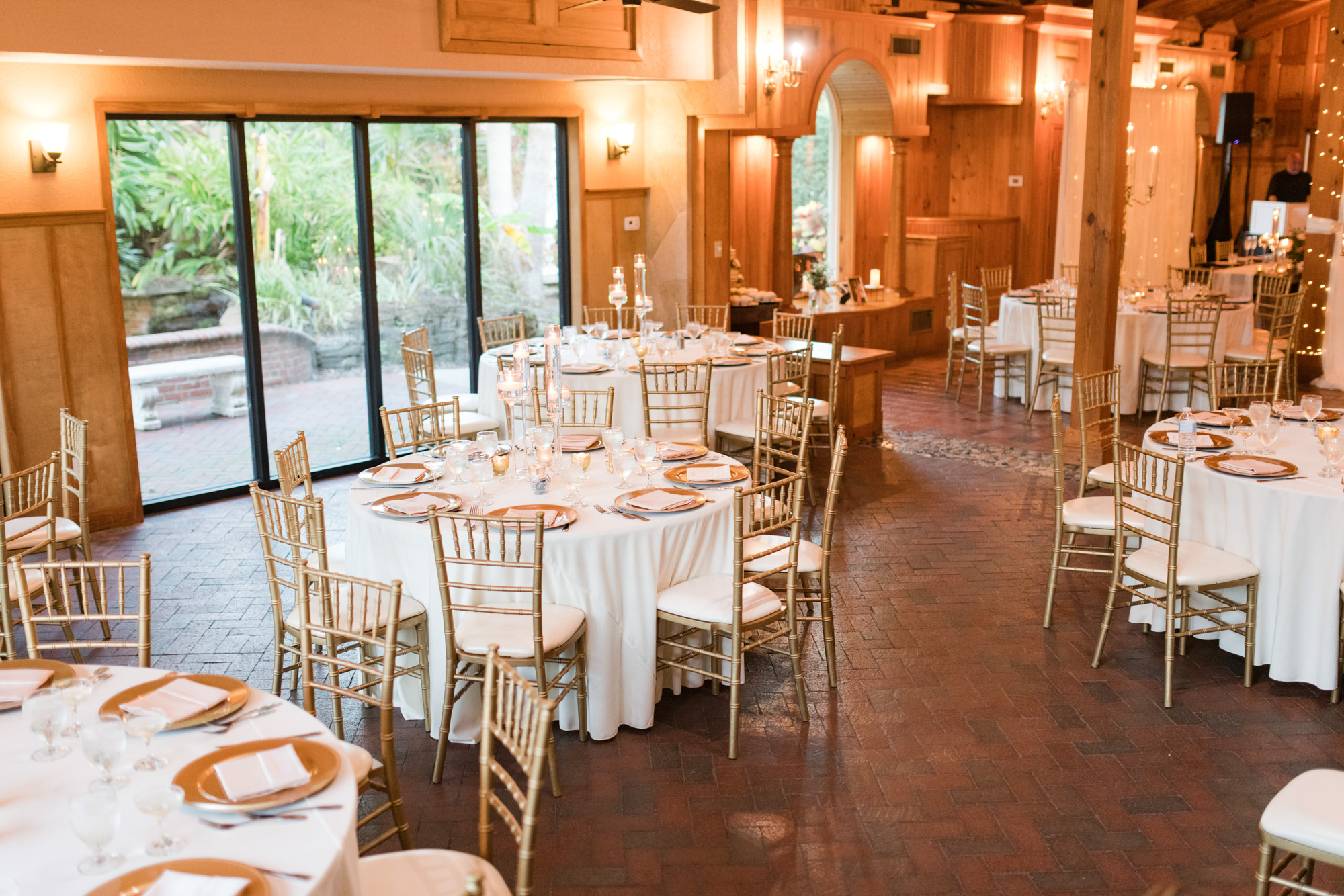 Estate on the Halifax reception room set with round tables, gold chairs and candlelight.