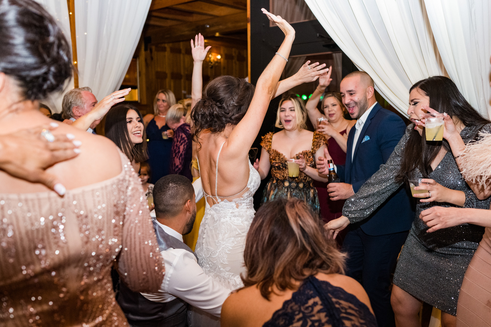 Bride dancing with her arms raised during the wedding reception at Estate on the Halifax.