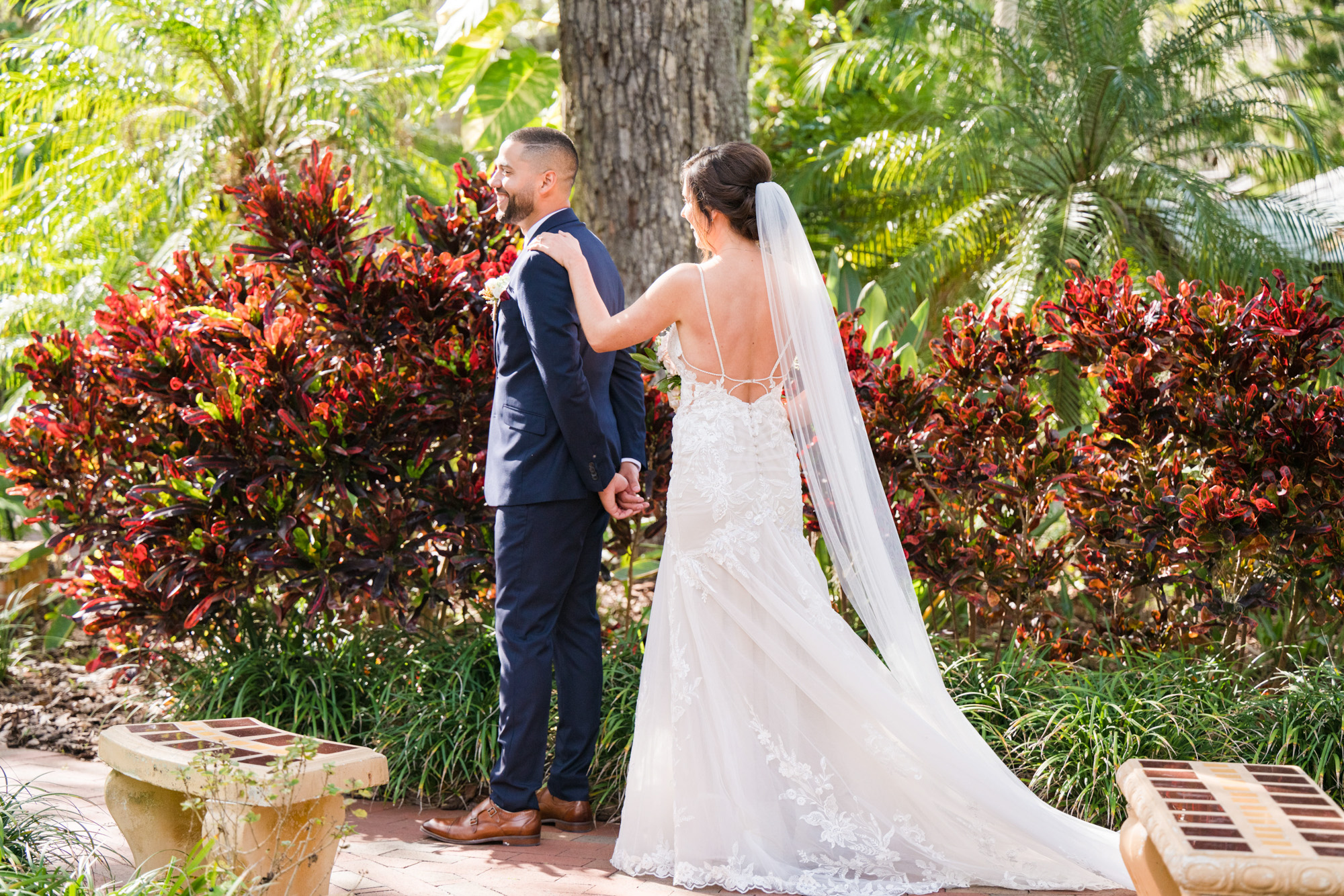 Bride approaching the groom from behind during their first look in the gardens at Estate on the Halifax.