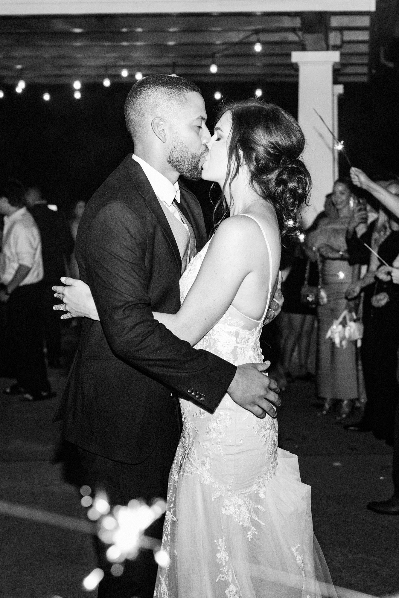 Bride and groom kissing during their sparkler send-off at the end of the wedding reception.