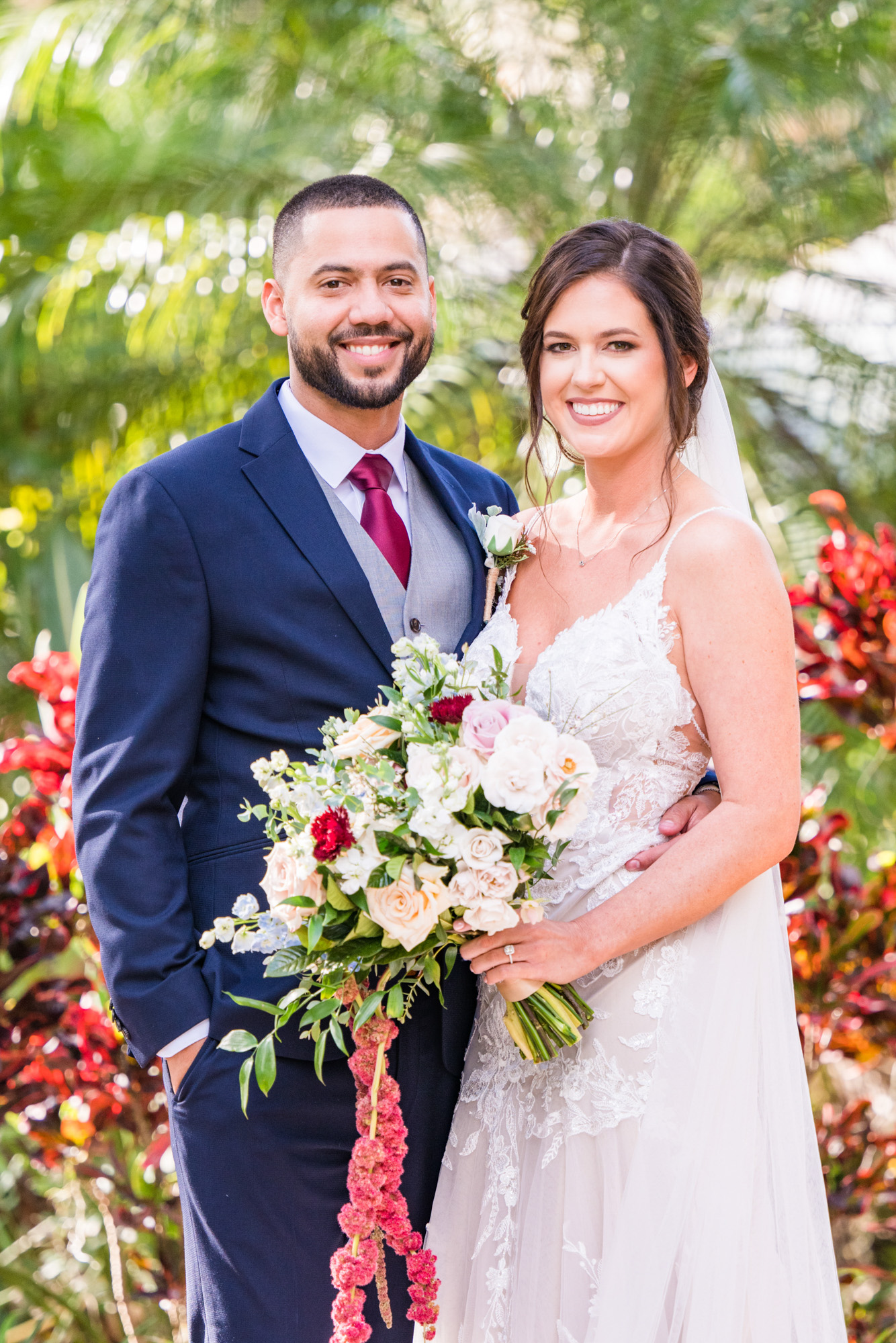 Bride and groom smiling together with tropical greenery behind them at Estate on the Halifax.