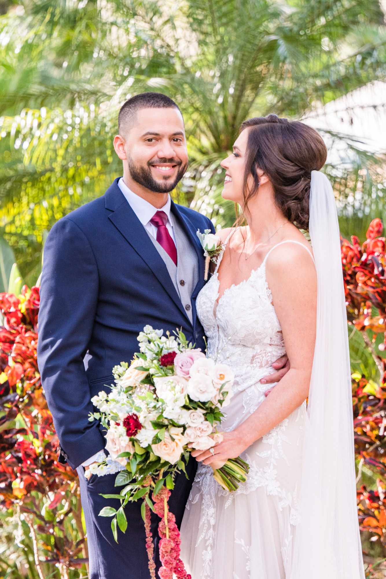 Groom smiling while the bride looks toward him during wedding portraits at Estate on the Halifax.