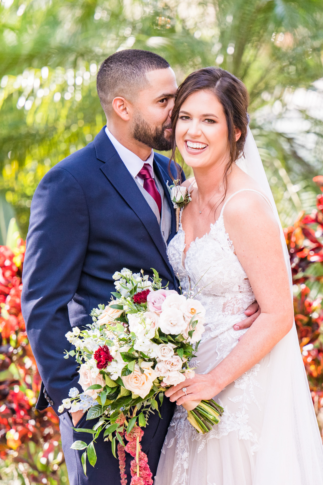 Groom kissing the bride on the cheek during romantic wedding portraits.