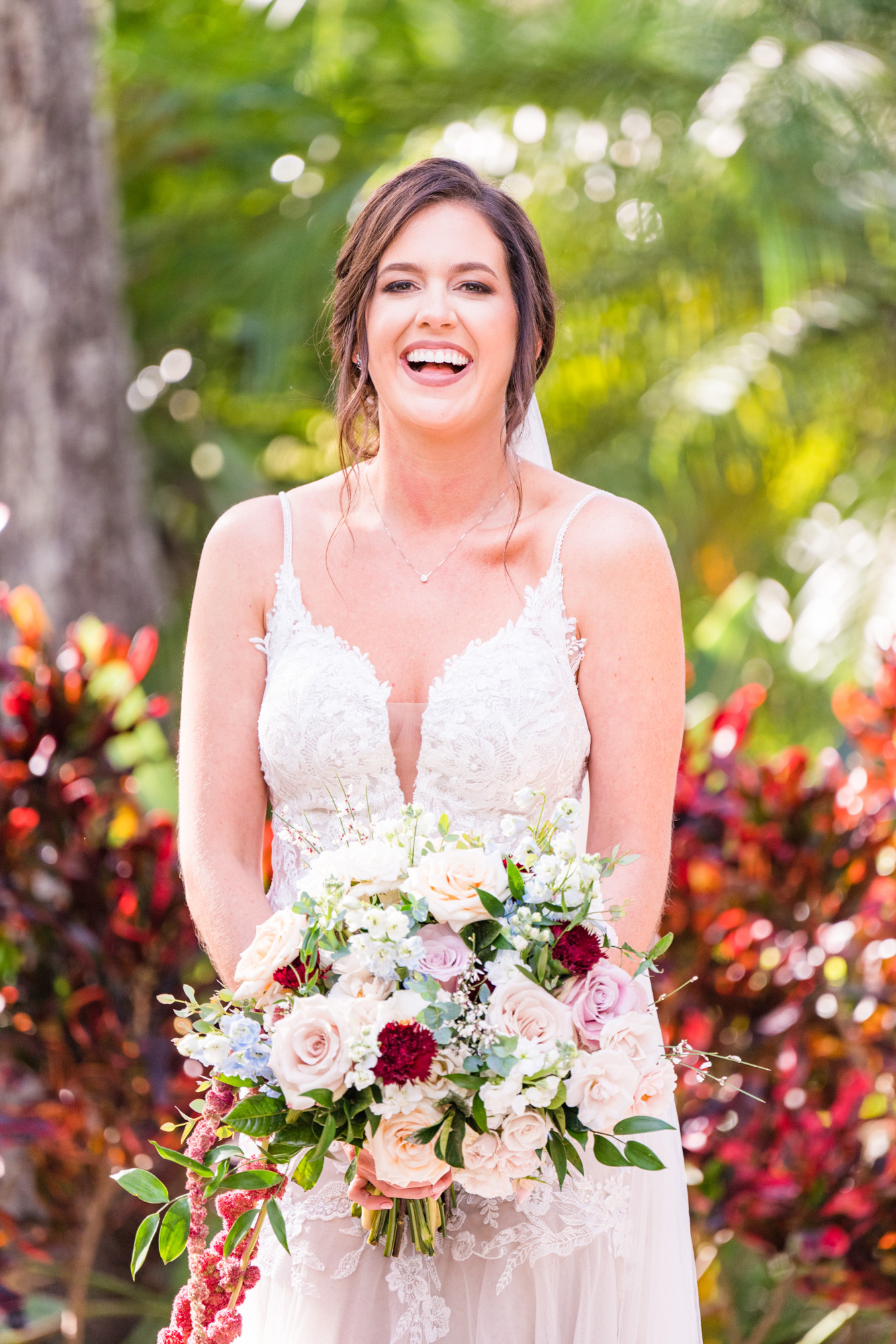 Close-up bridal portrait with a soft floral bouquet and tropical greenery at Estate on the Halifax.