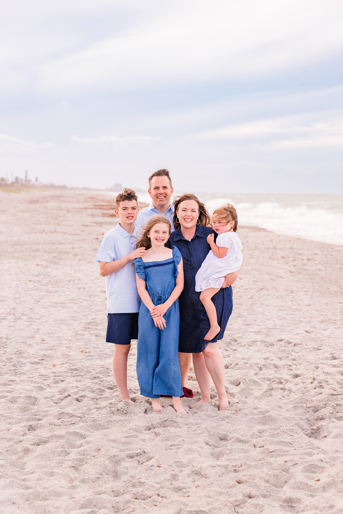 Family of five on Melbourne Beach while the wind blows down the beach