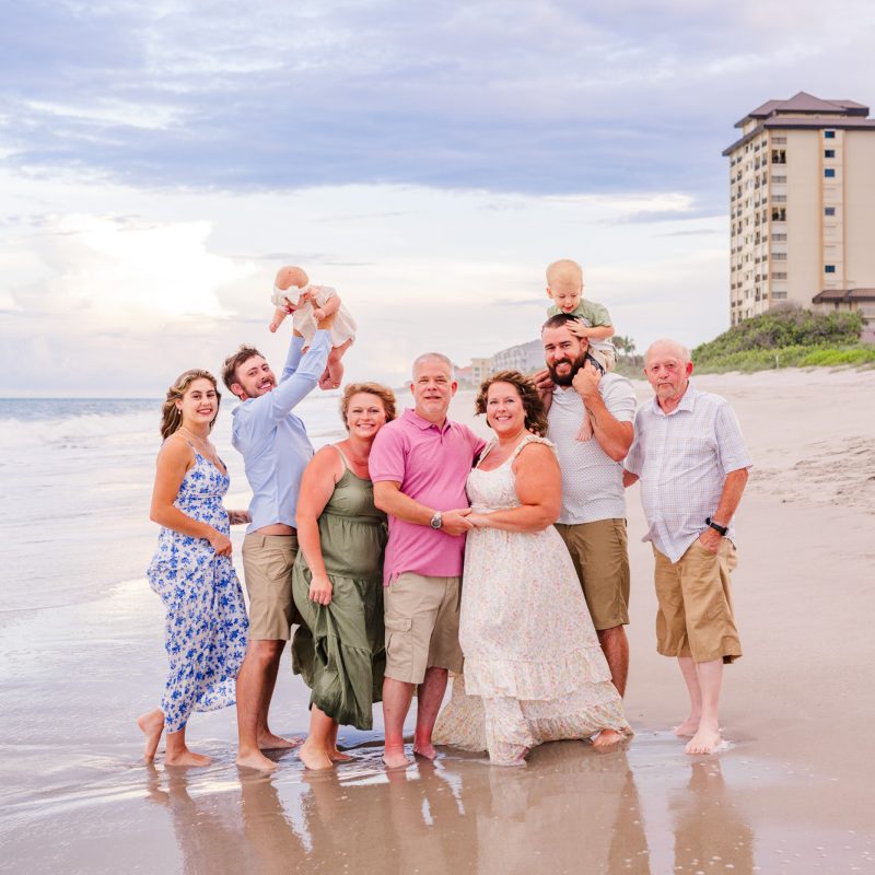 extended family at the beach wearing pinks and blues during a family session on Melbourne Beach
