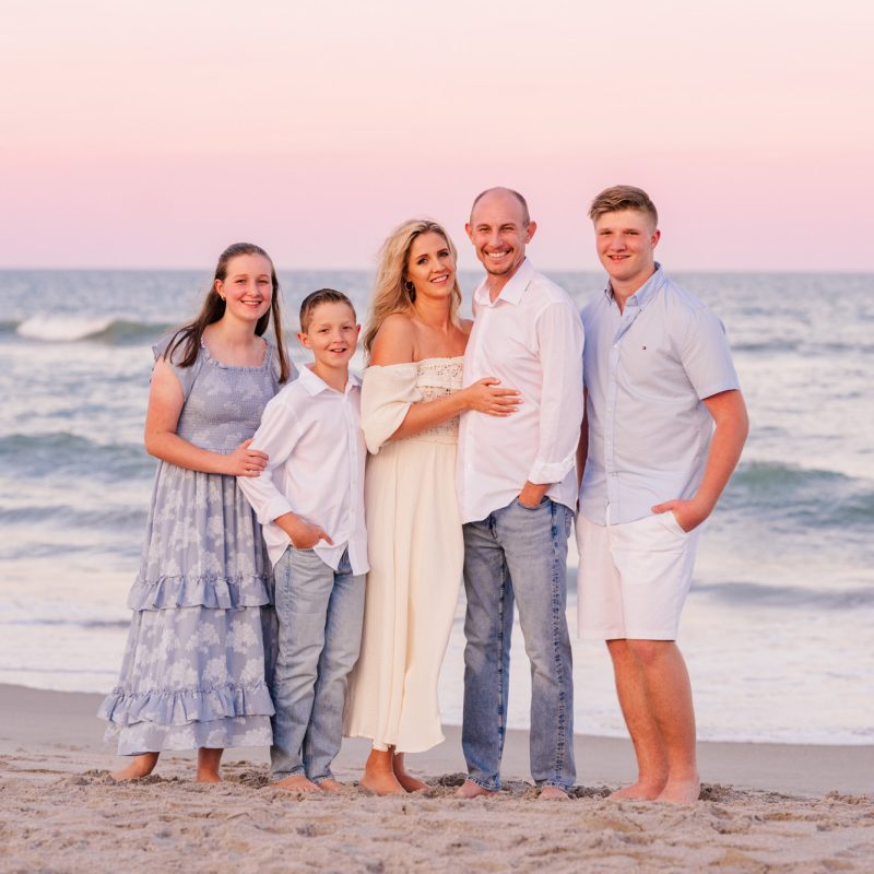 Family of five posing in front of the ocean at sunset on Melbourne Beach
