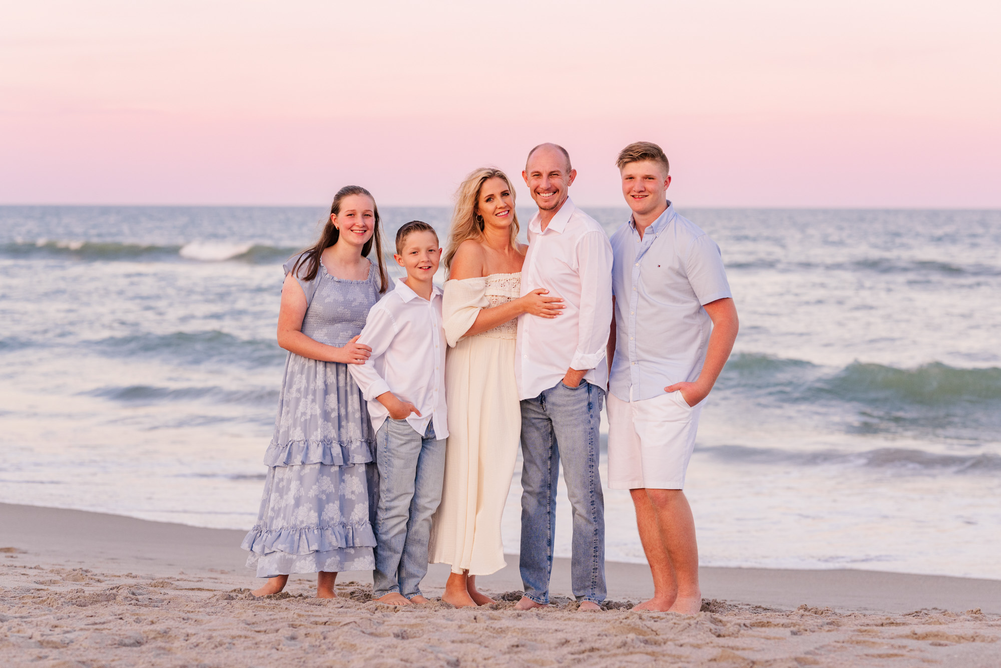 Family of five posing in front of the ocean at sunset on Melbourne Beach