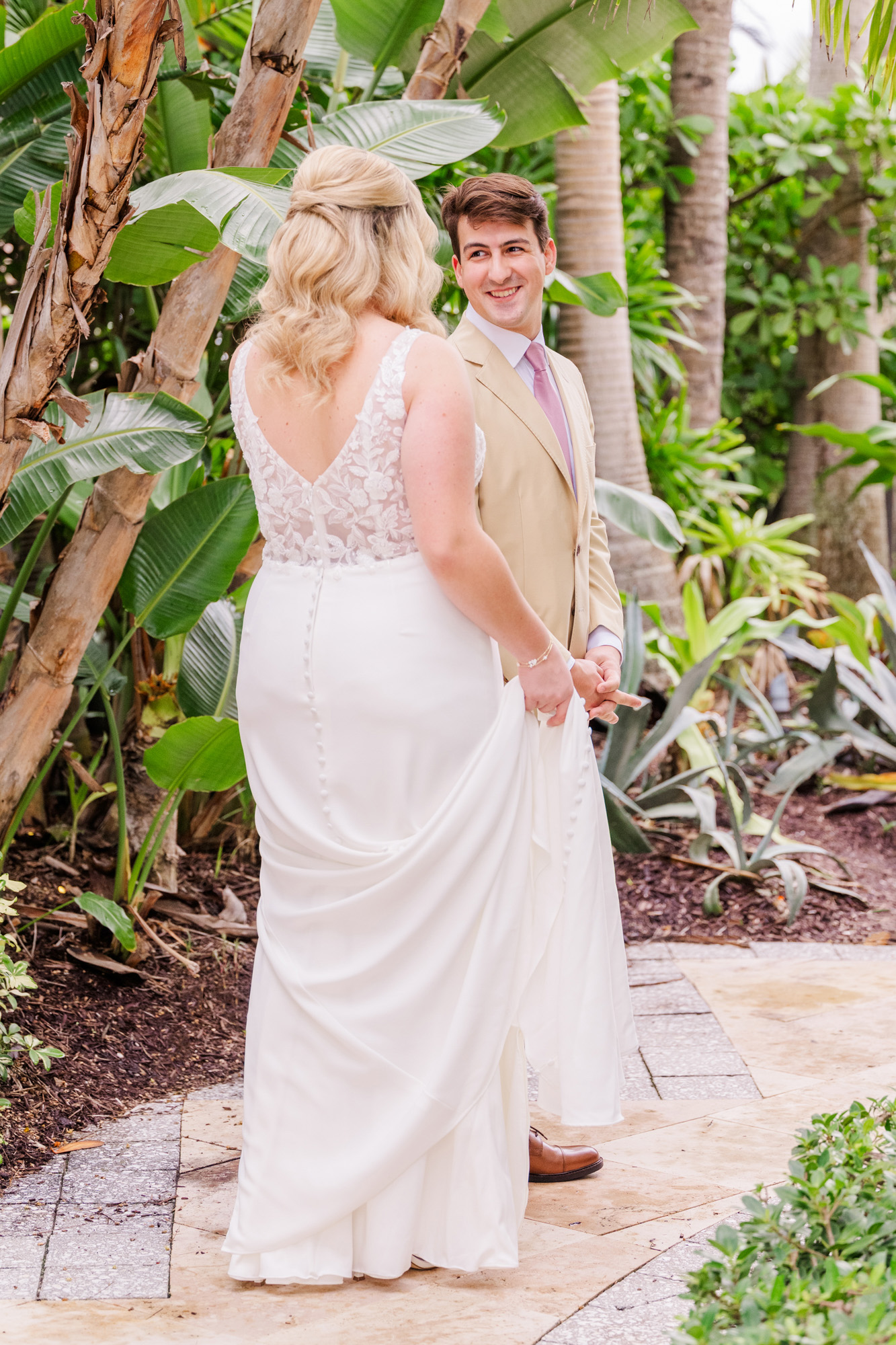 Groom turns and smiles at the bride during their wedding first look.