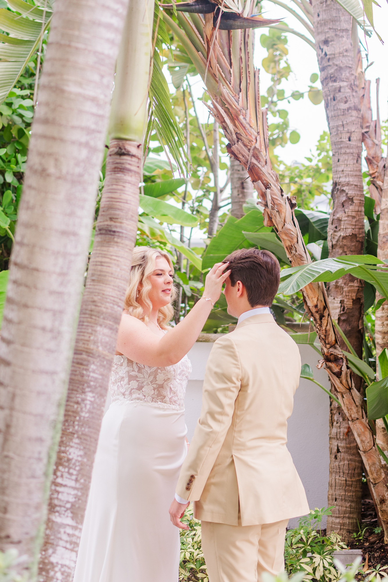 Bride playfully fixes the groom’s hair during their wedding first look.