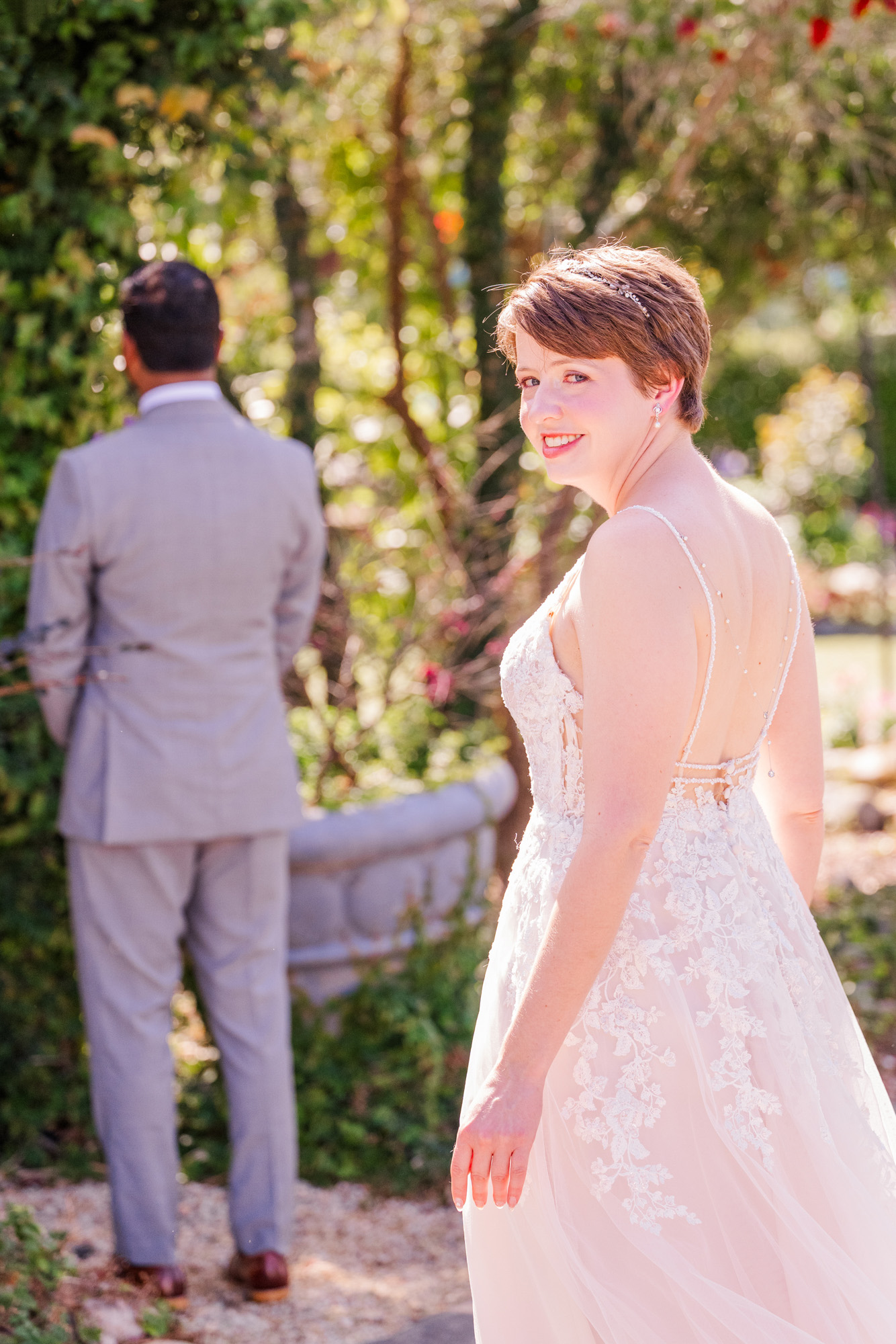 Bride approaches the groom from behind before their outdoor wedding first look at Rockledge Gardens.