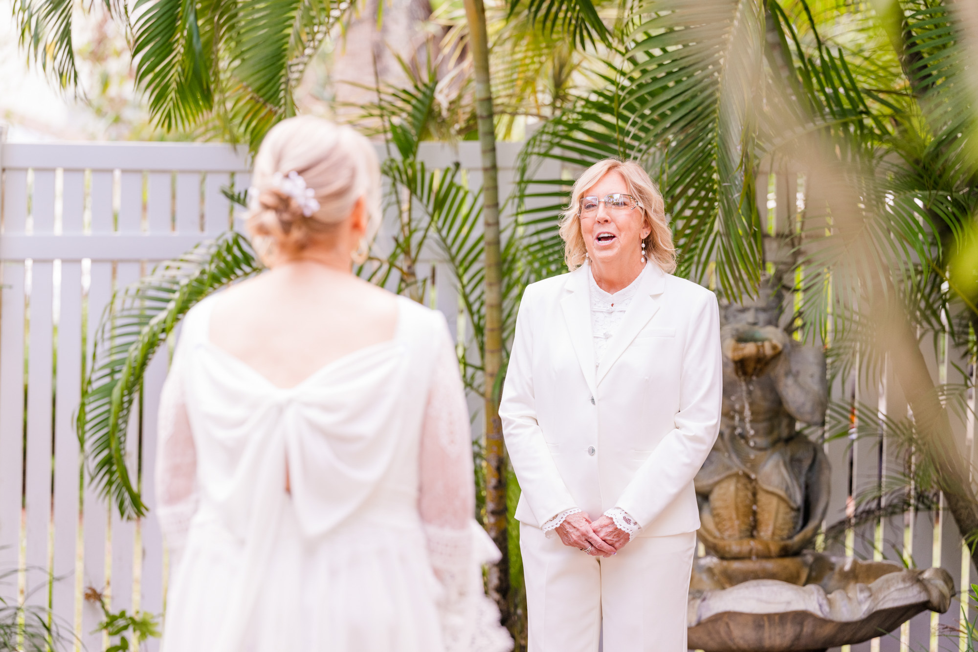 Bride smiles at her partner during an emotional first look before their wedding ceremony.