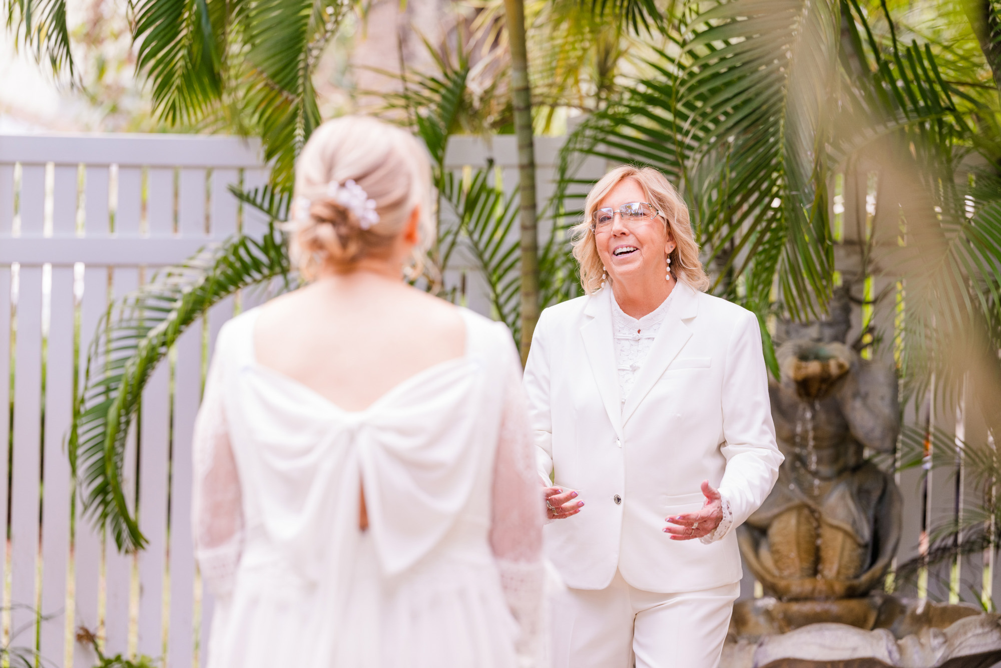 Bride talks to her partner during their intimate wedding first look in a lush garden setting.