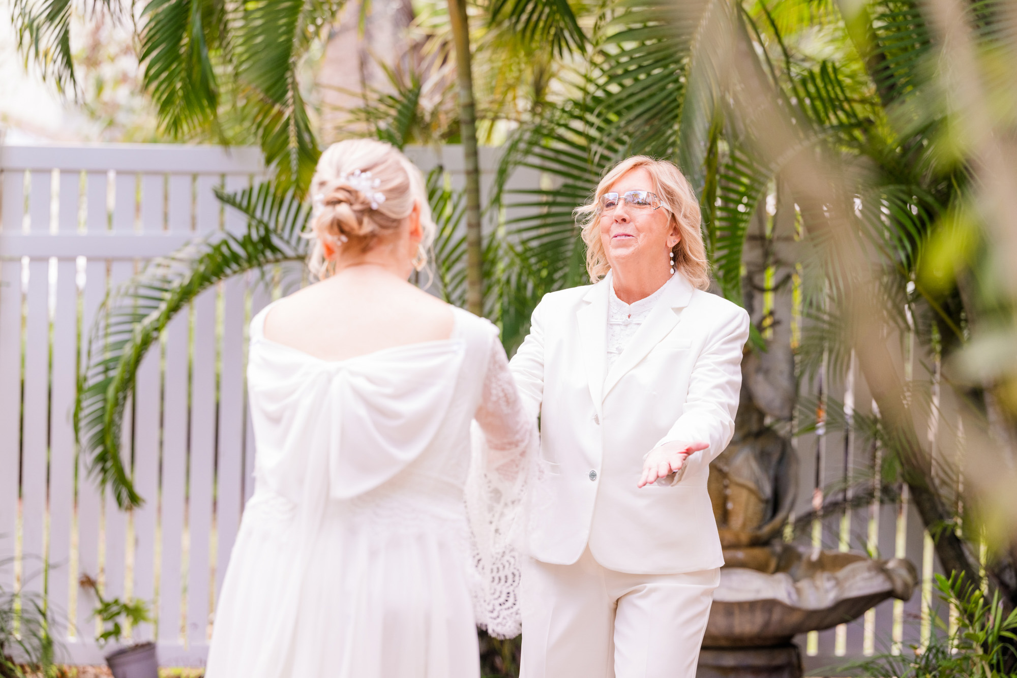 Bride reaches toward her partner during a sweet and emotional wedding first look.