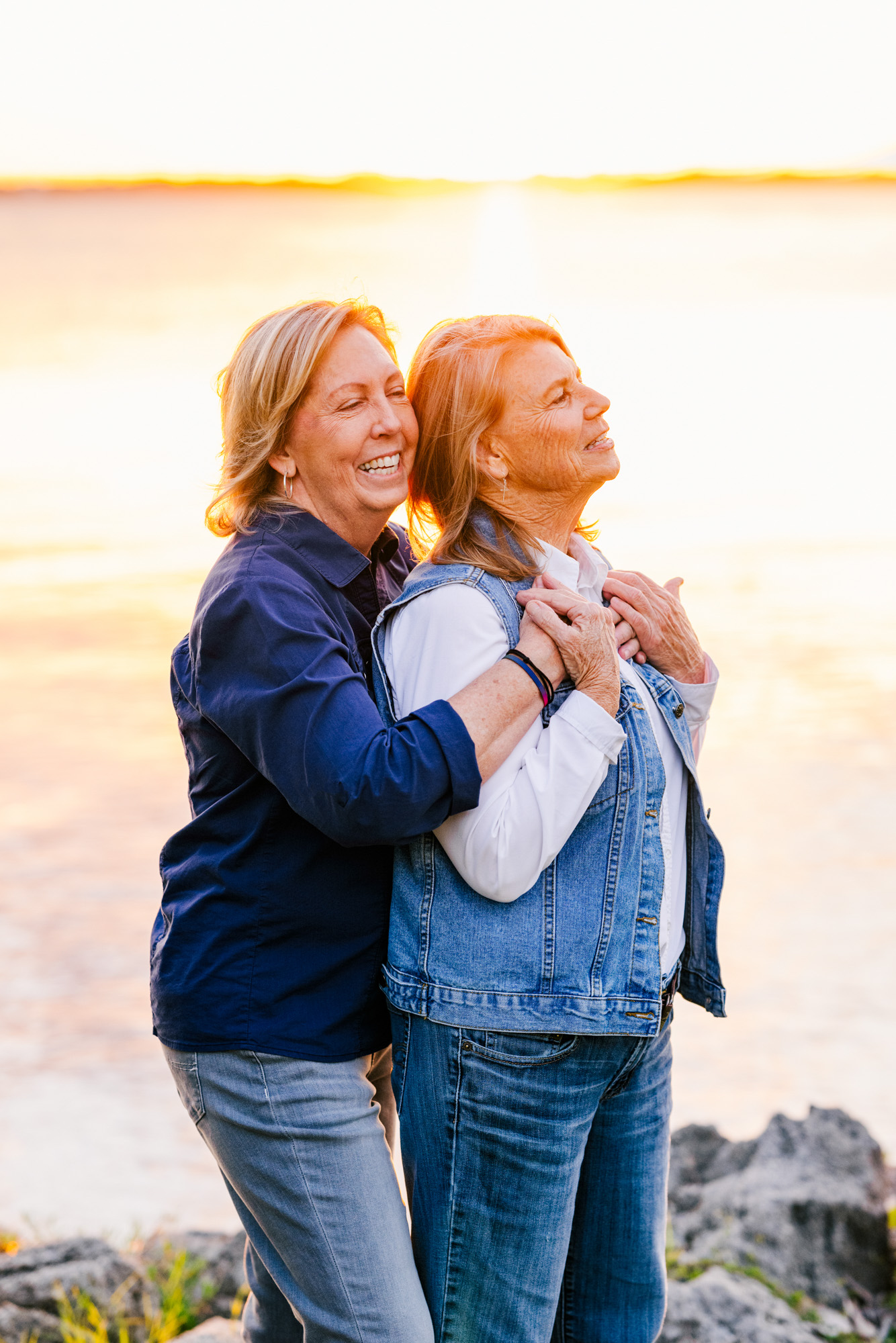 Two women hugging during beautiful sunset on pier in Melbourne Beach