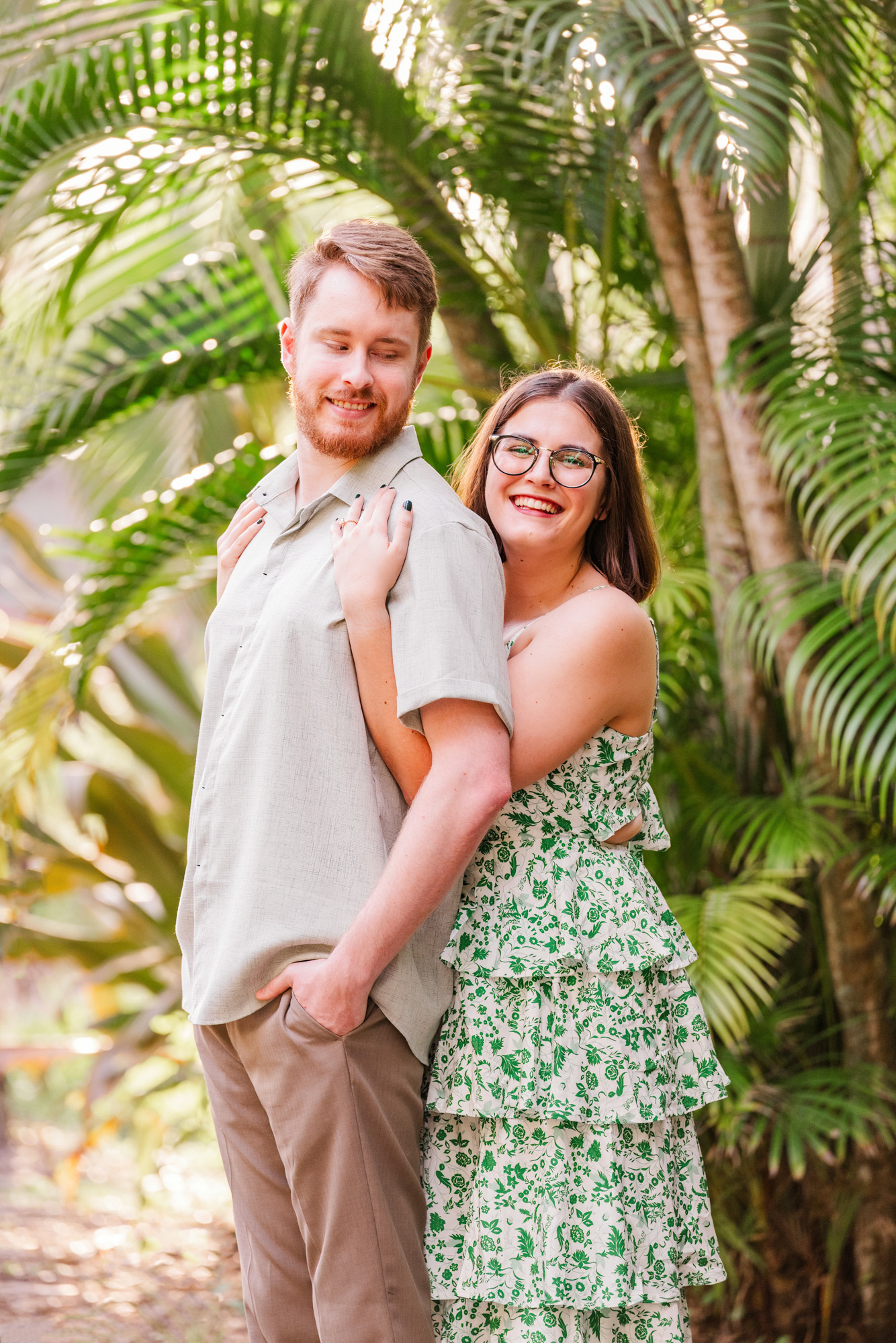woman in green dress hugging boyfriend in the botanical gardens at Florida Tech