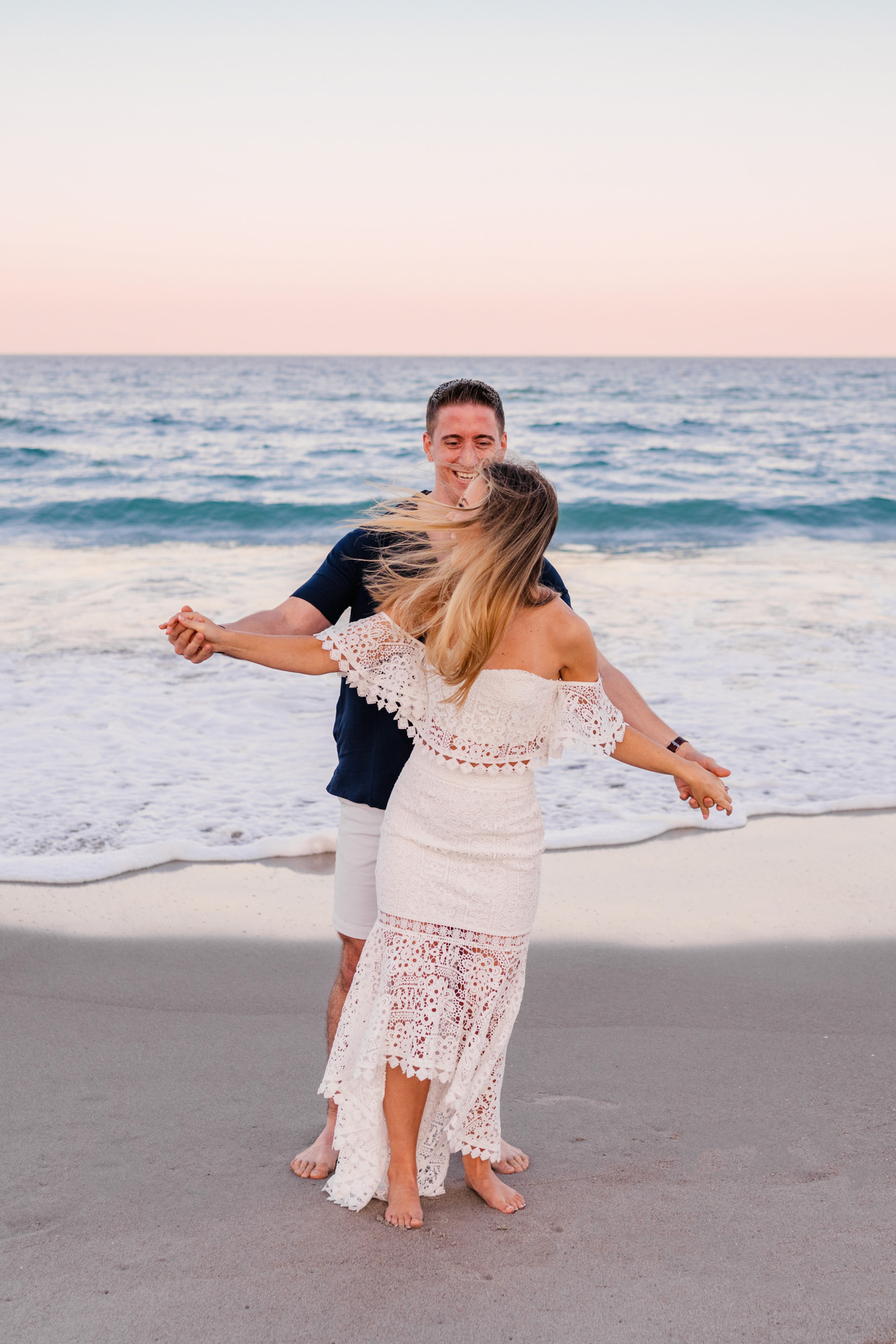 Man playing airplane with girlfriend on Melbourne Beach