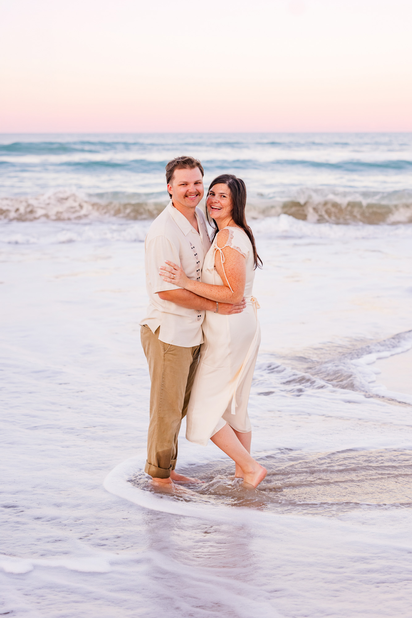 Man and woman hugging while standing in the water