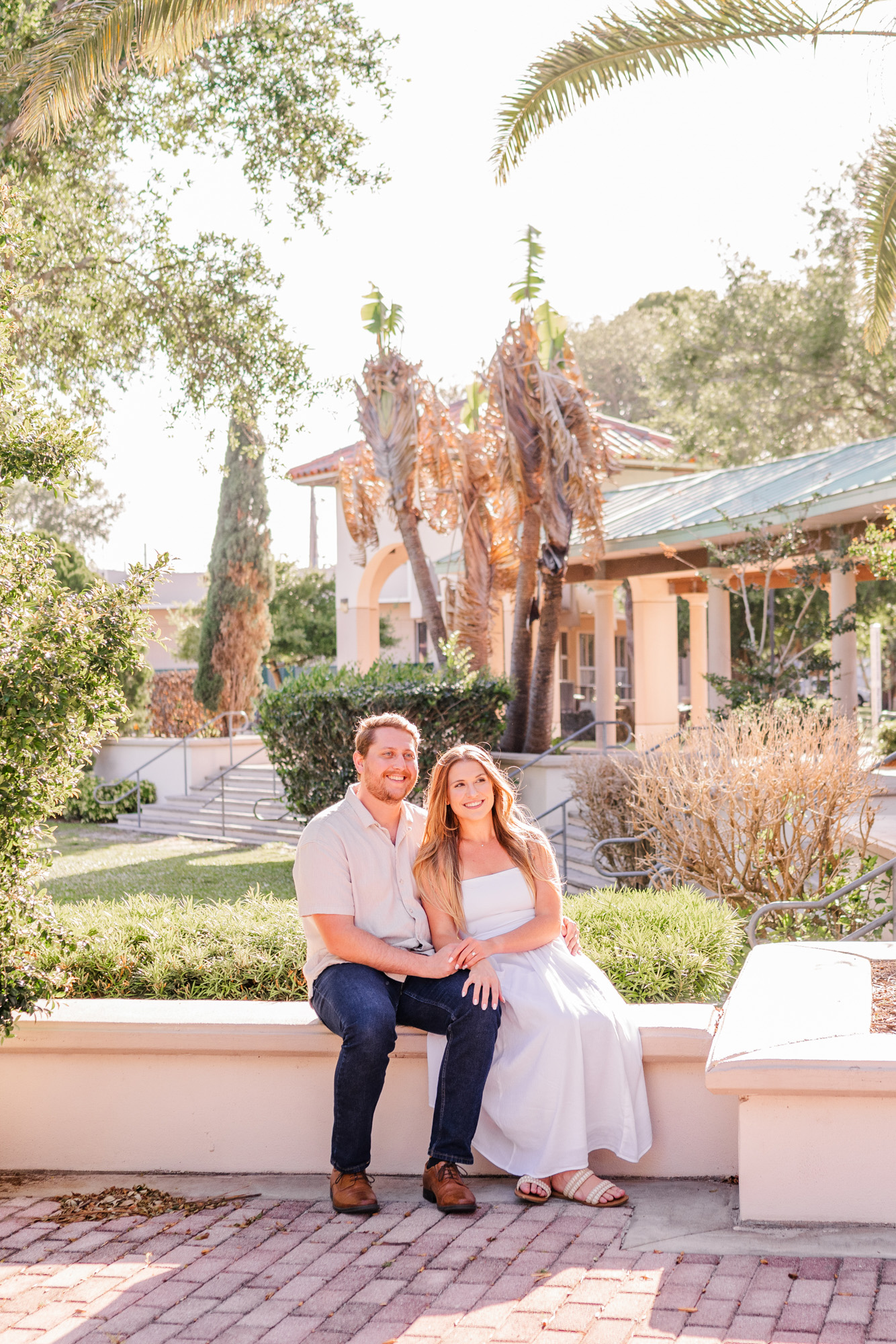 Couple sitting on ledge in Cocoa Village engagement session
