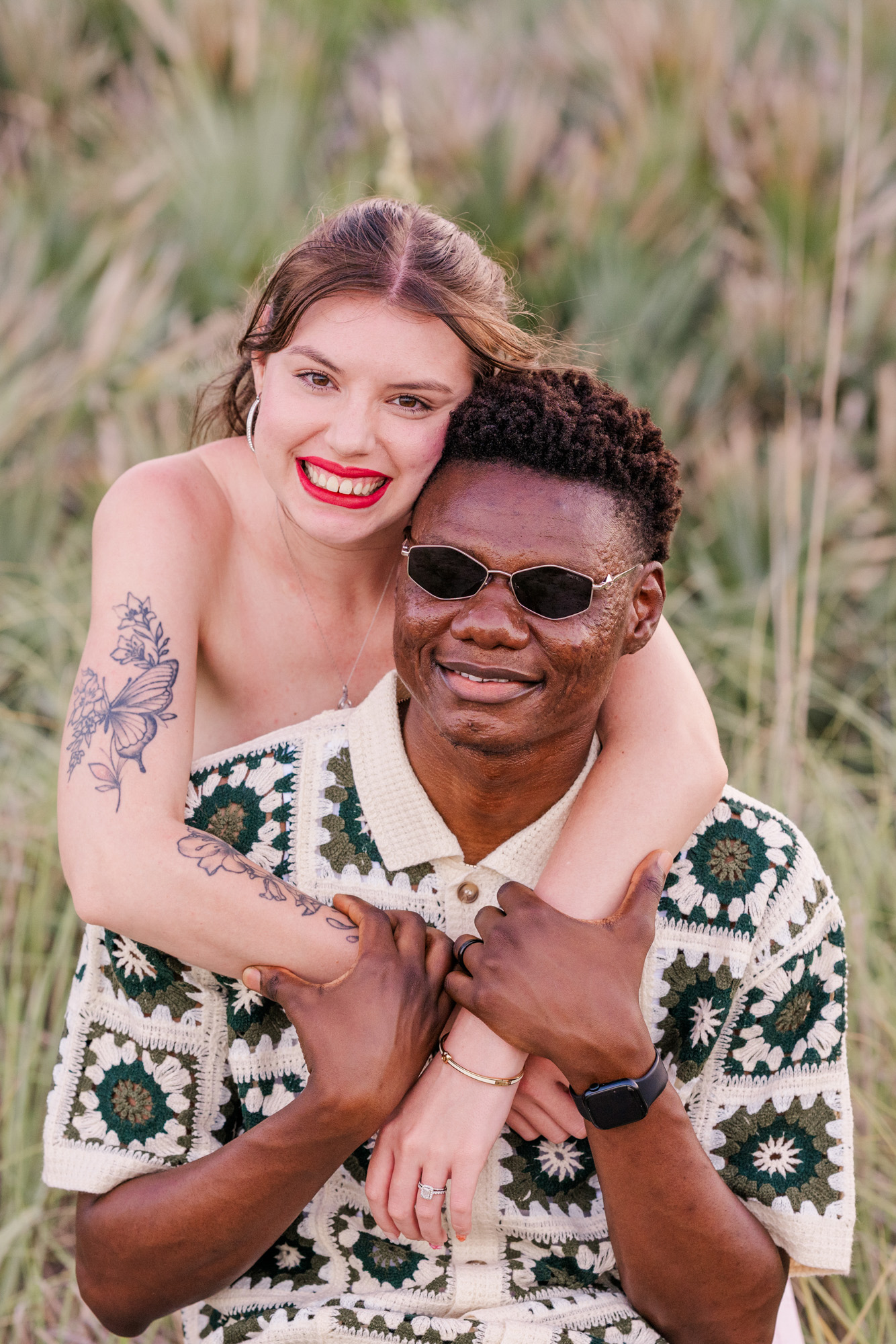 Woman in a pink dress hugging man in a checked shirt