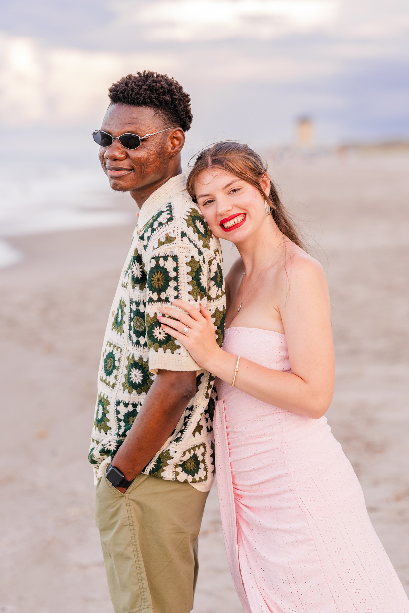 Man wearing fun green and white shirt with woman in a pink dress