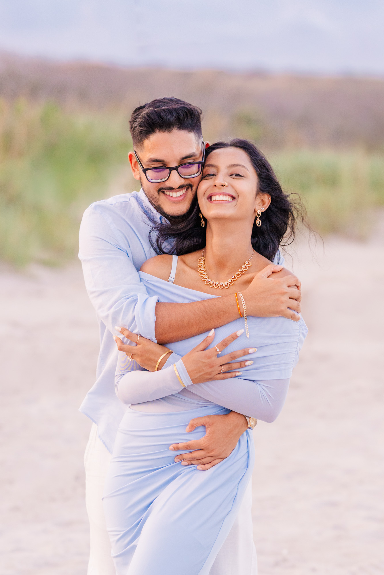 Man and woman dressed in light blue hugging on Cocoa Beach, Florida