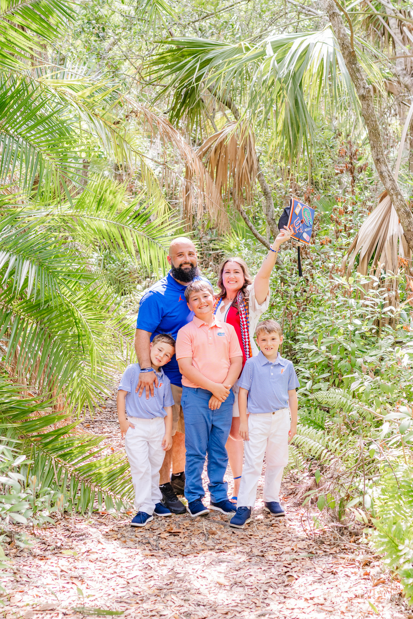 Graduate posing with her family of five at the Florida Tech Botanical Gardens.