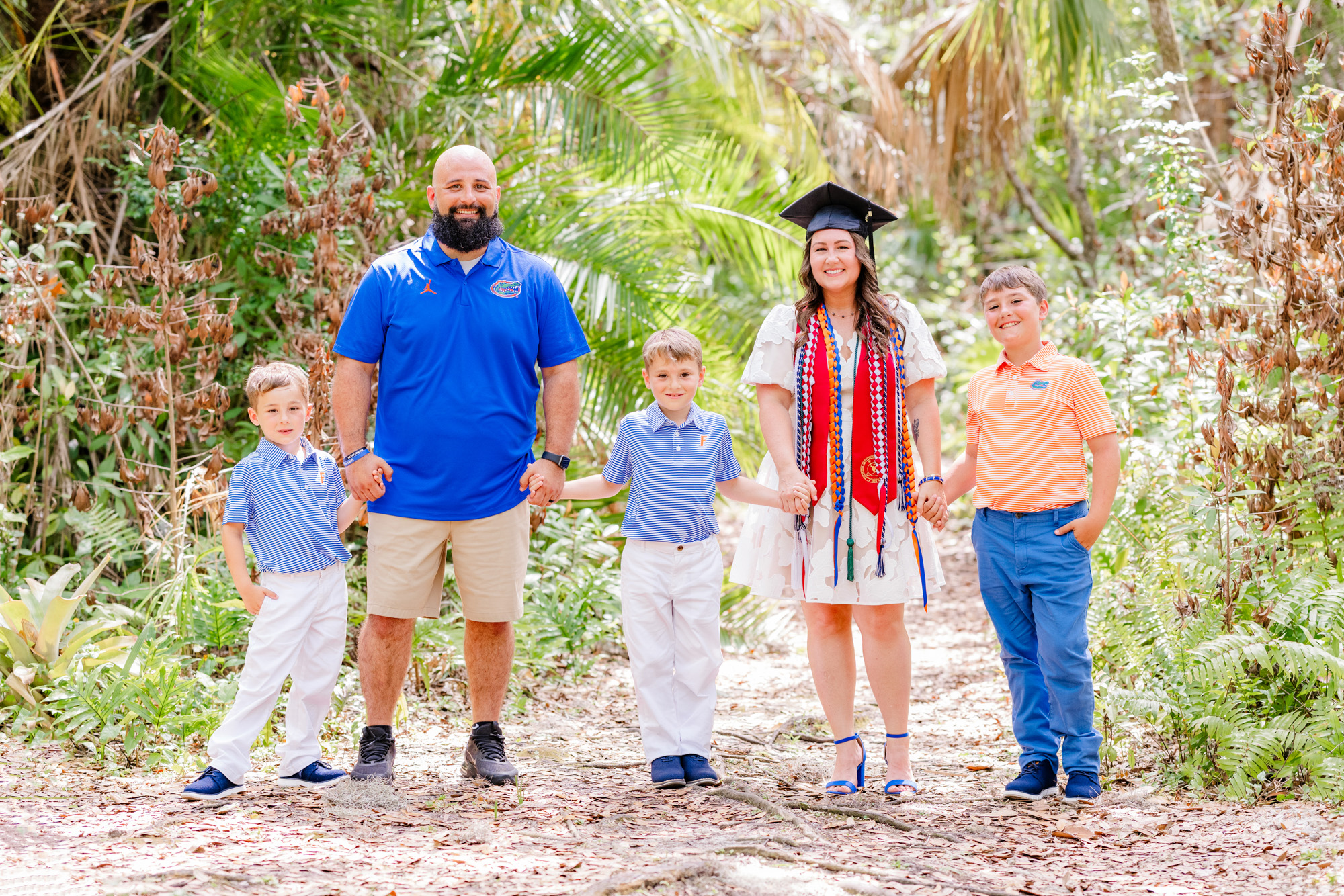 Graduate standing with her partner and three boys during their Melbourne family session.