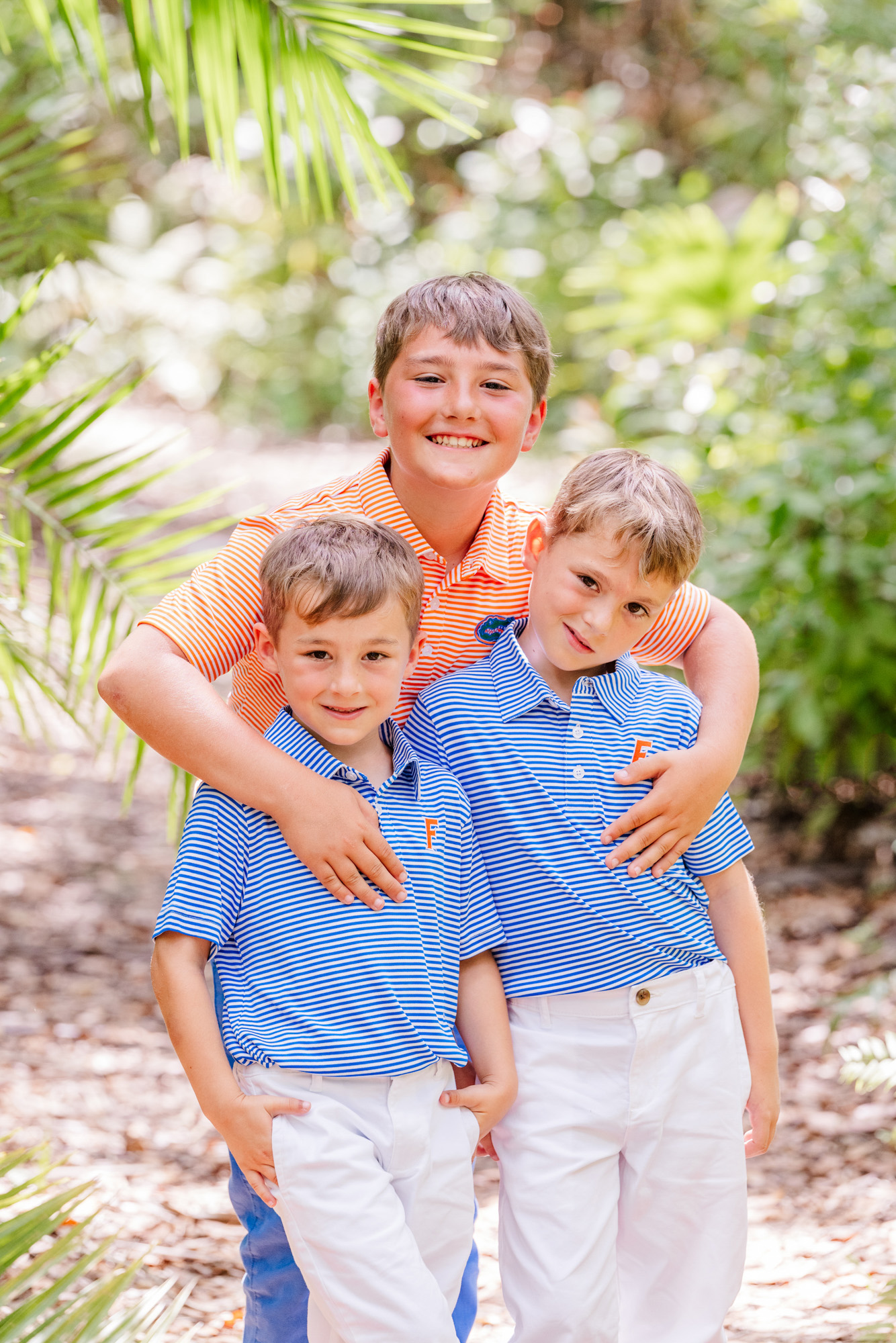 Older boy wrapping his arms around two younger boys during their family session.