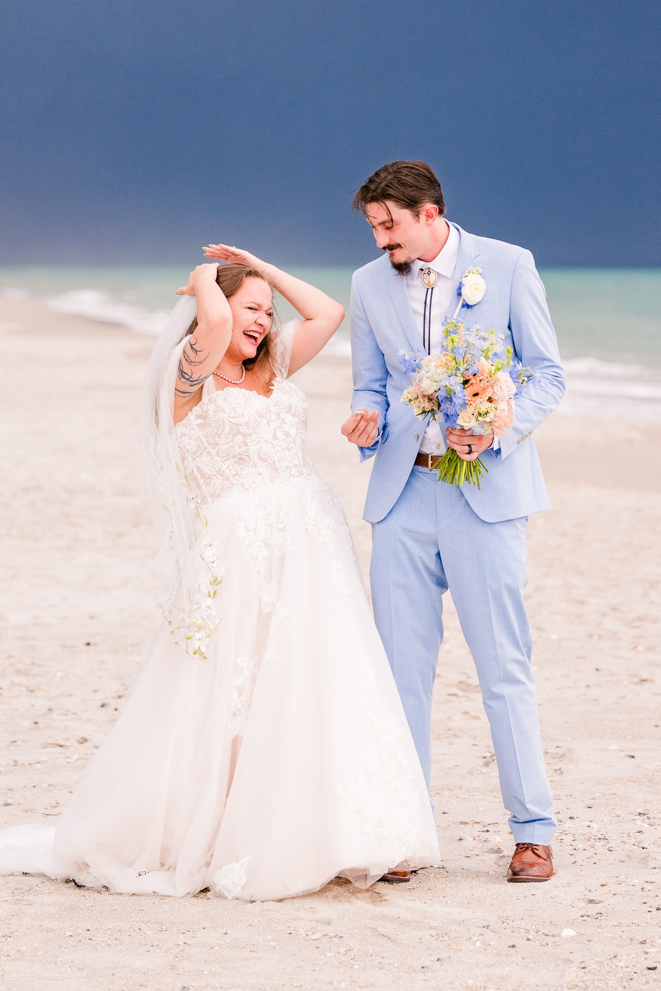 Bride holding onto her veil due to the high wind