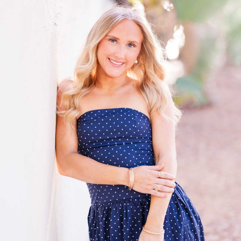 High school senior in blue dress leaning on wall in Melbourne Beach