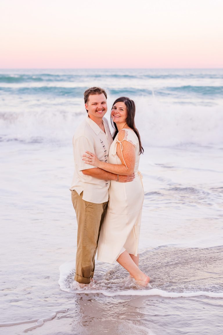 Couple hugging on beach with beautiful sunset in the background