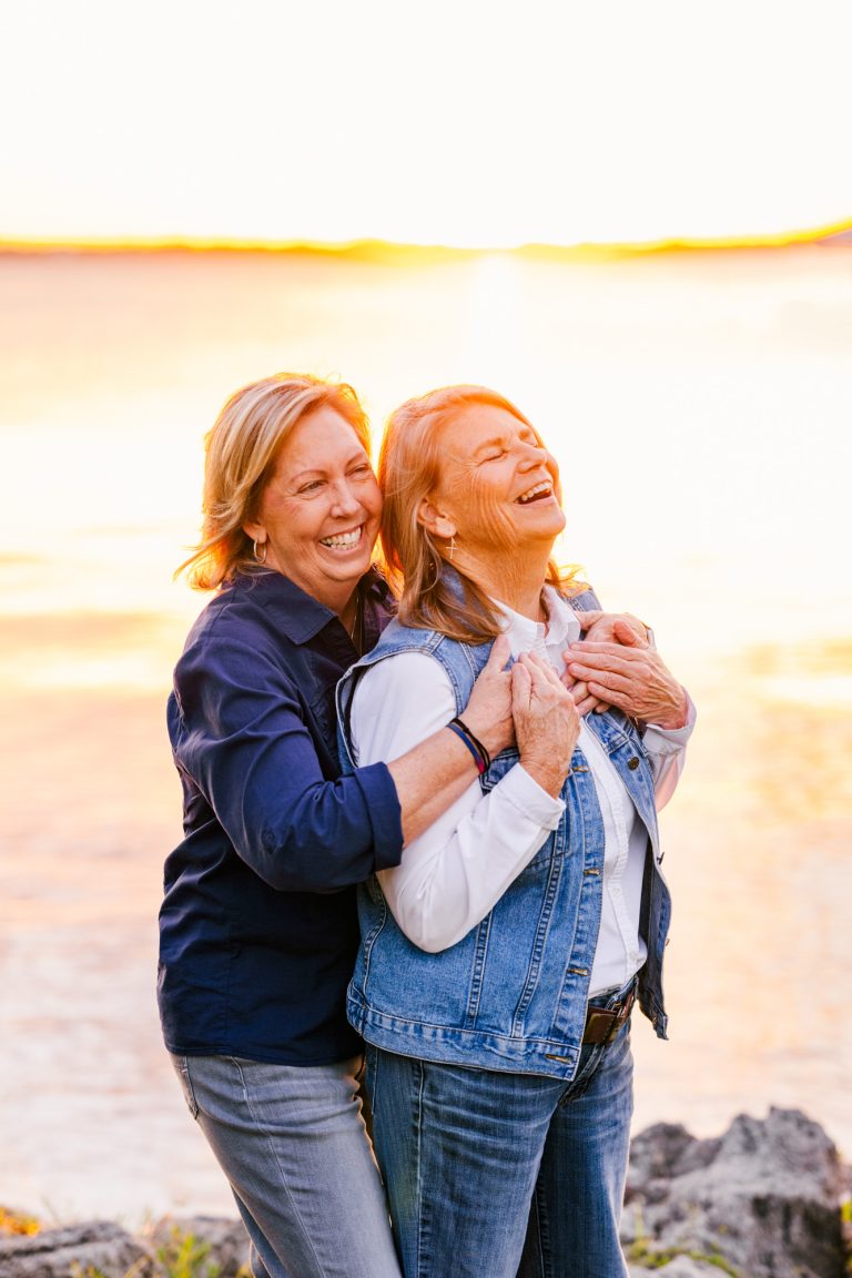 two women hugging near the river in Melbourne Beach during a beautiful sunset