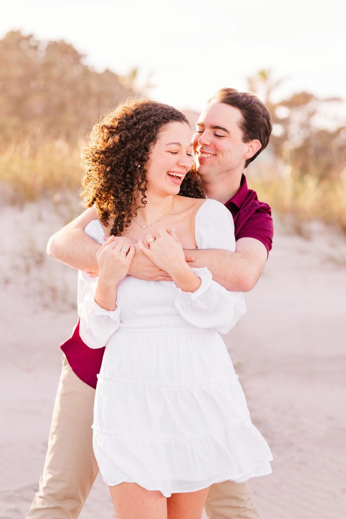 Coulple hugging on beach during a Melbourne Beach engagement session.