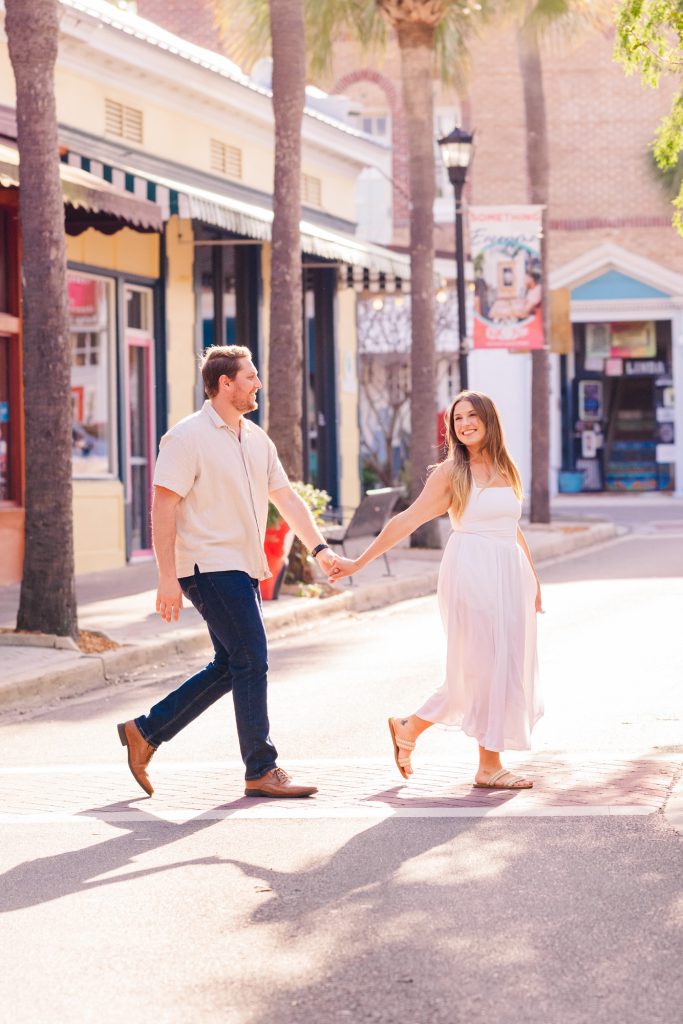Couple holding hands and crossing the street in Cocoa Village