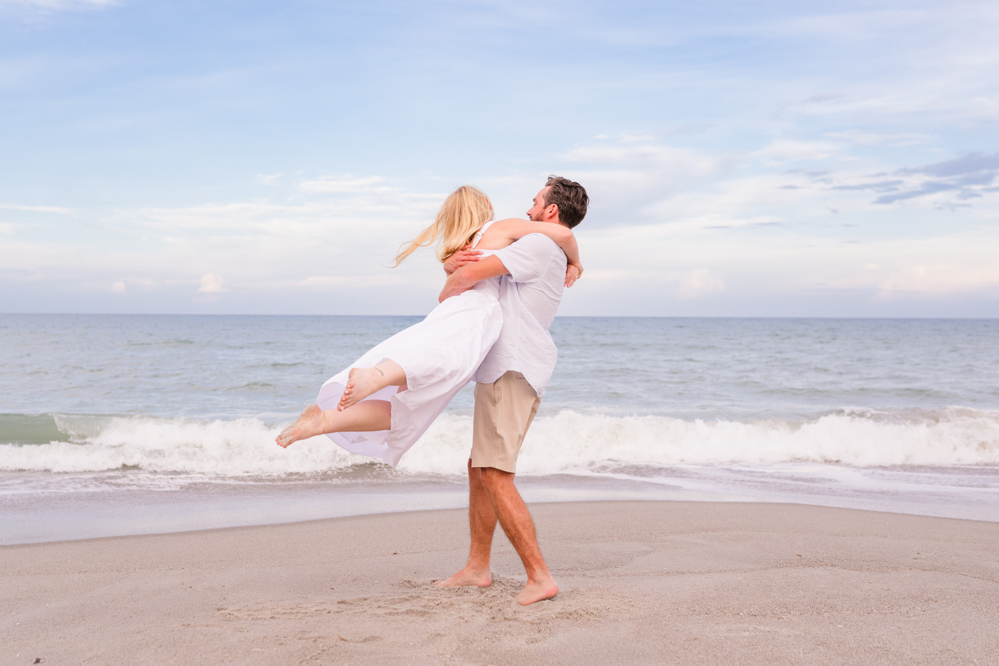 Man lifting girl off the ground and spinning on Melbourne Beach, Florida