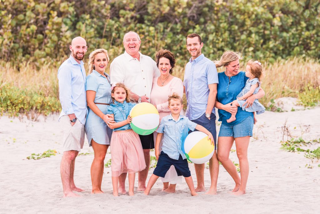 big family holding beach balls on cocoa beach florida